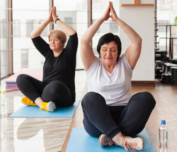 Seniors participating in a group exercise class, smiling and socialising.