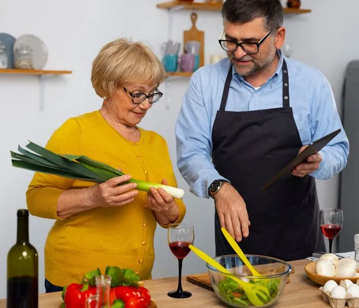 A home care worker assisting an elderly woman with preparing a meal in her kitchen